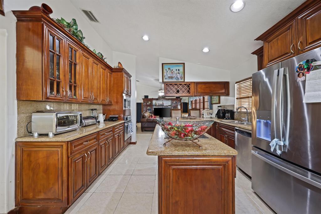 5172 Northwest 84th Road Coral Springs, FL 33067 - Photo 8 of 24 a kitchen with stainless steel appliances granite countertop a refrigerator a stove top oven a sink and dishwasher