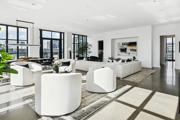 a living room with furniture large window and wooden floor