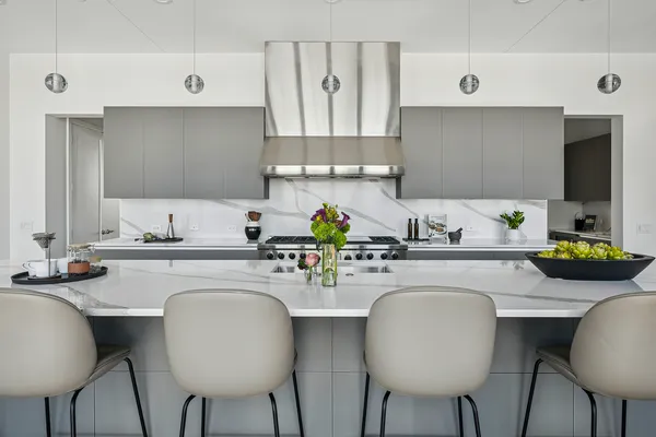 a kitchen with stainless steel appliances a table and chairs in it