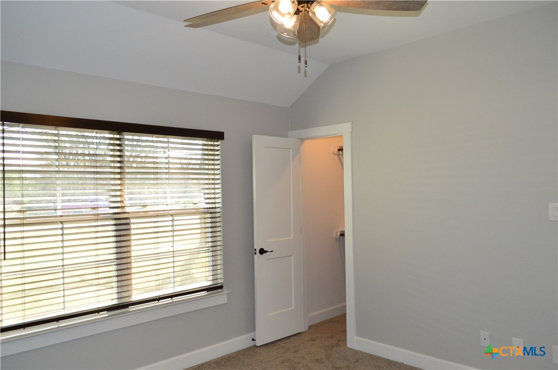 1026 County Road 3152 Kempner, TX 76539 - Photo 25 of 48 Bedroom Two with High Ceiling, Ceiling Fan, and Walk-in Closet ** Add a door to the small hallway, and this area could be a mother-in-law suite.