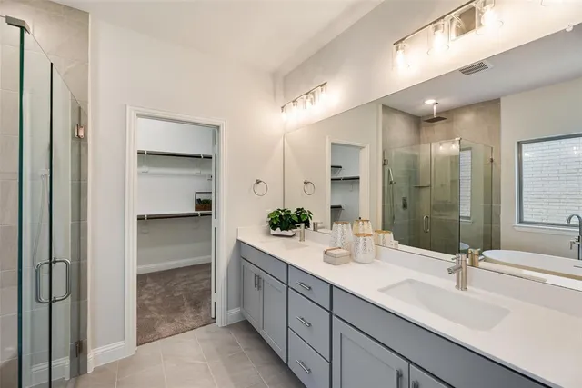 a spacious bathroom with a double vanity sink mirror and shower