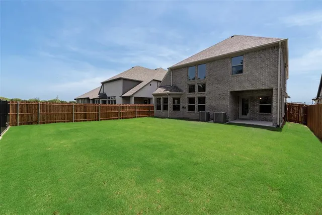 a view of a house with a big yard potted plants and large tree