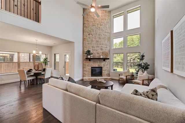 a living room with fireplace furniture and a large window