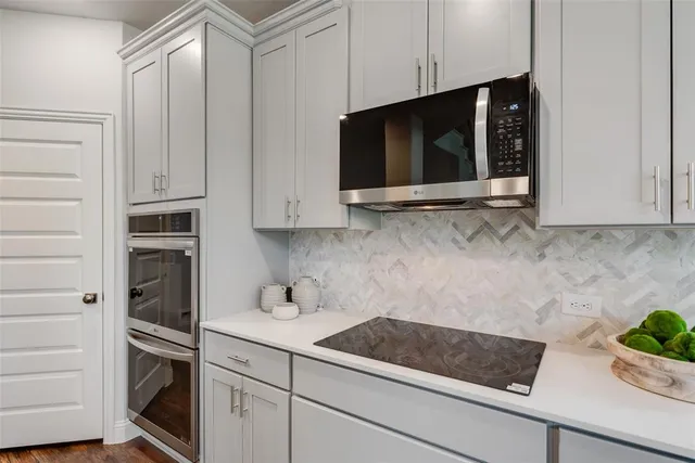 a kitchen with stainless steel appliances white cabinets and a microwave oven