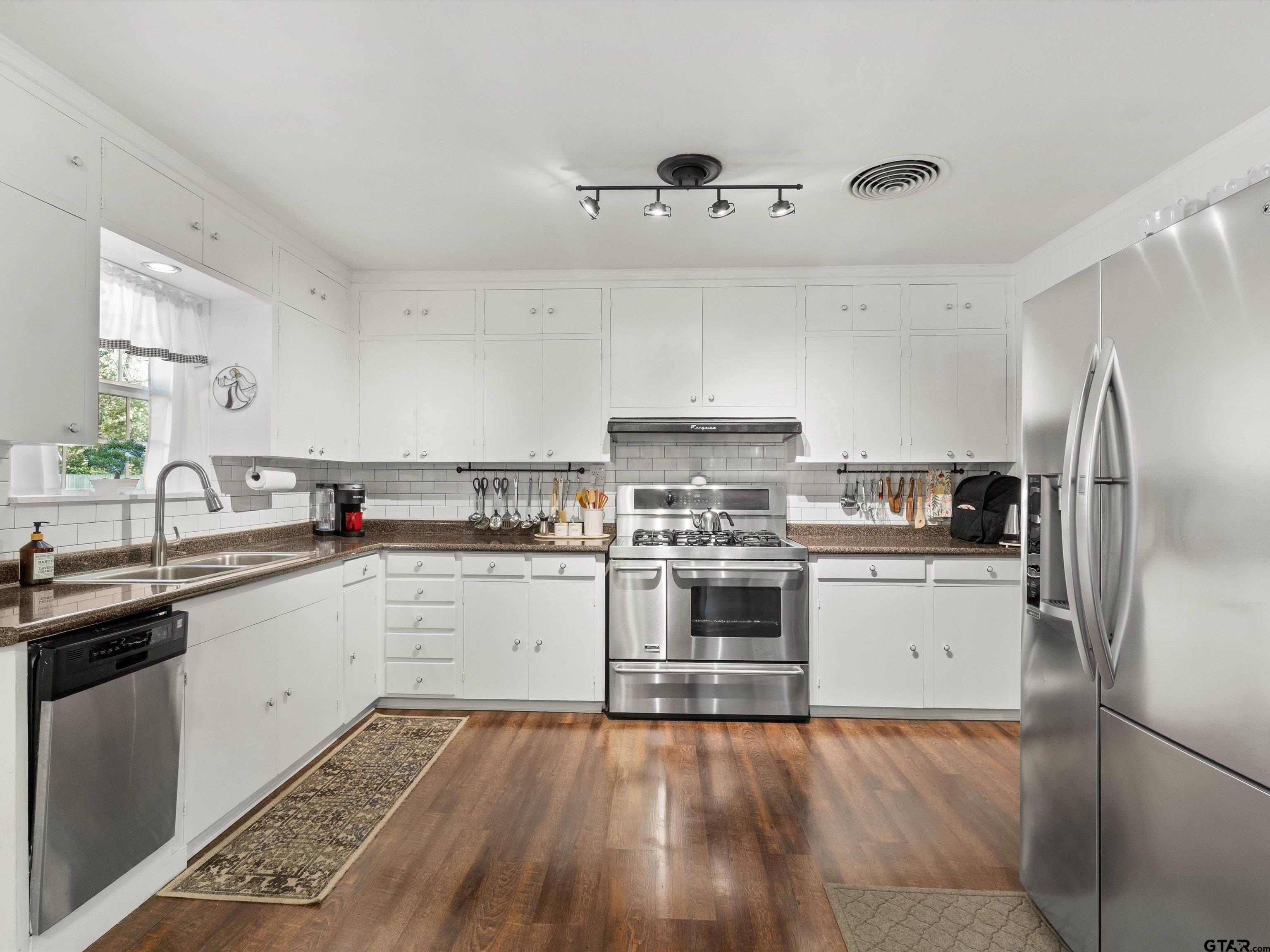 618 Walnut Street Gilmer, TX 75644 - Photo 17 of 30 a kitchen with granite countertop a sink stainless steel appliances and cabinets