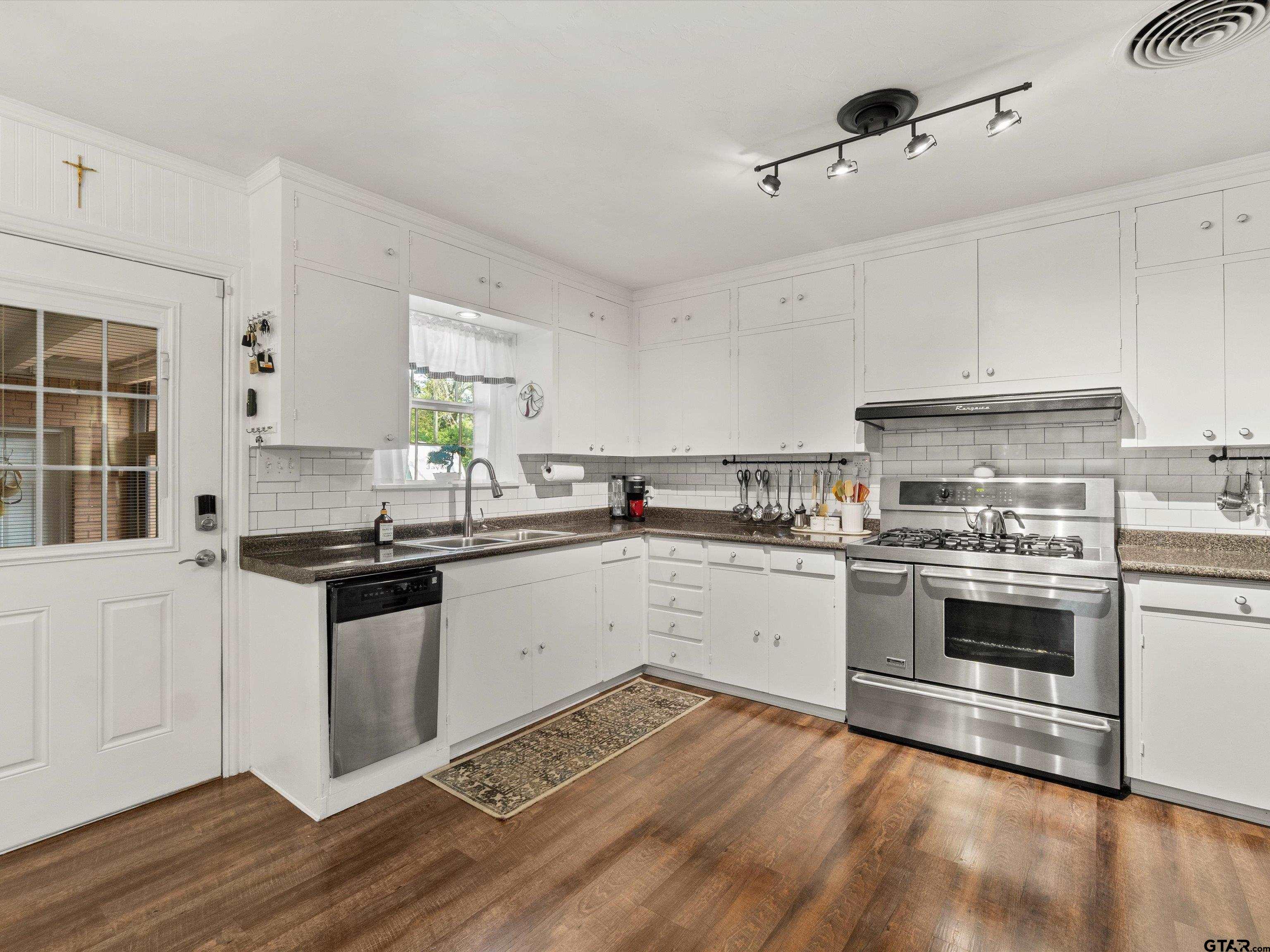 618 Walnut Street Gilmer, TX 75644 - Photo 19 of 30 a kitchen with granite countertop a stove top oven sink and cabinets