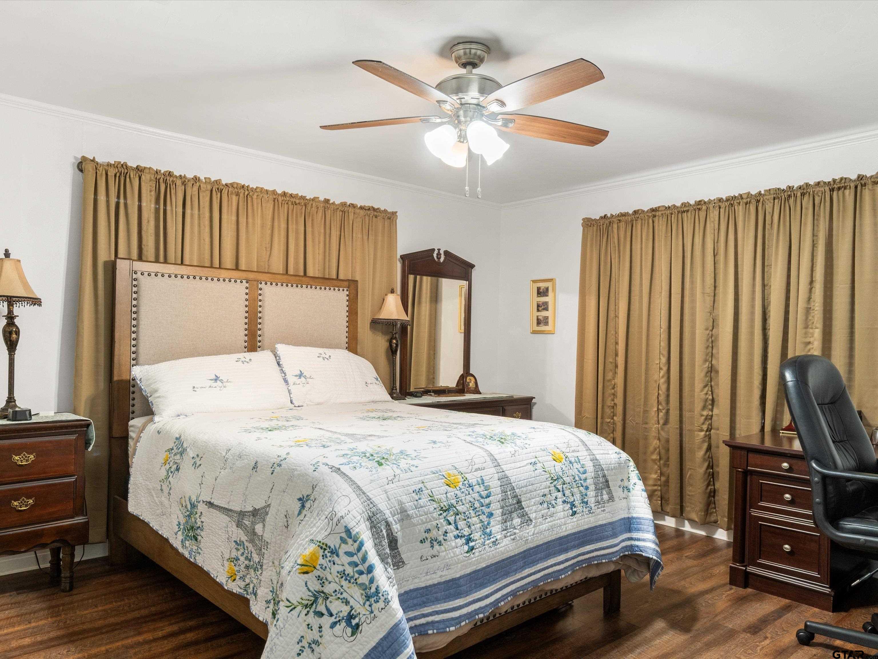 618 Walnut Street Gilmer, TX 75644 - Photo 23 of 30 a bedroom with a bed and a flat tv screen on dresser