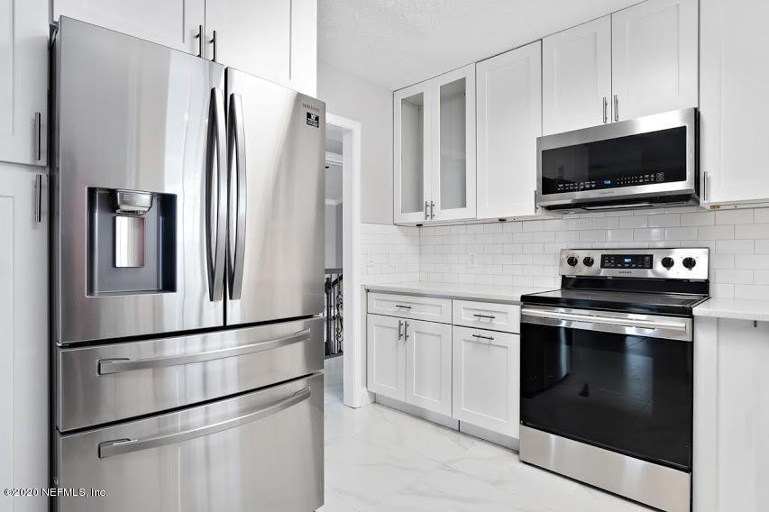 4283 Heath Road Jacksonville, FL 32277 - Photo 11 of 30 a kitchen with stainless steel appliances white cabinets and a granite counter top