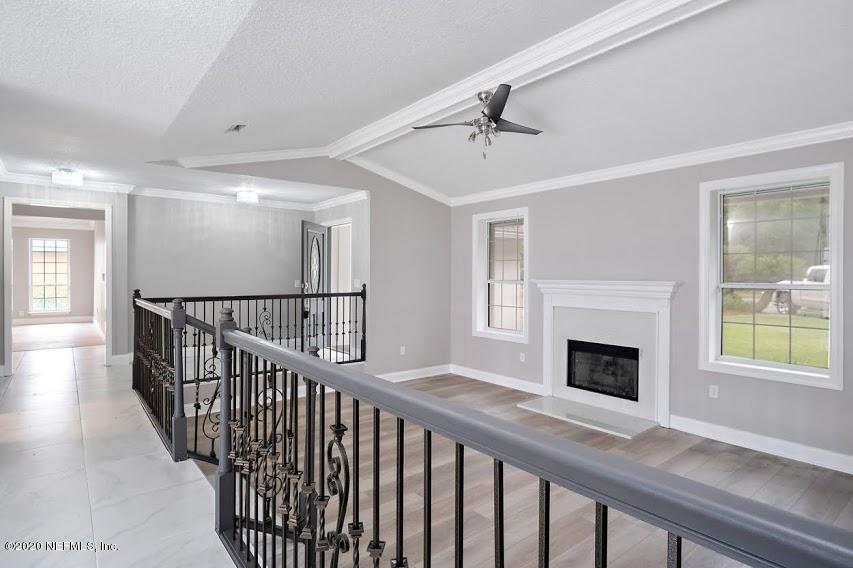 4283 Heath Road Jacksonville, FL 32277 - Photo 7 of 30 a view of an empty room with wooden floor fireplace and a window