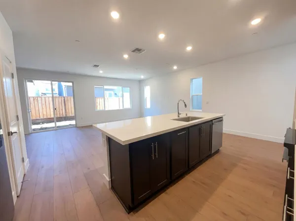 a kitchen with a sink and cabinet with wooden floor