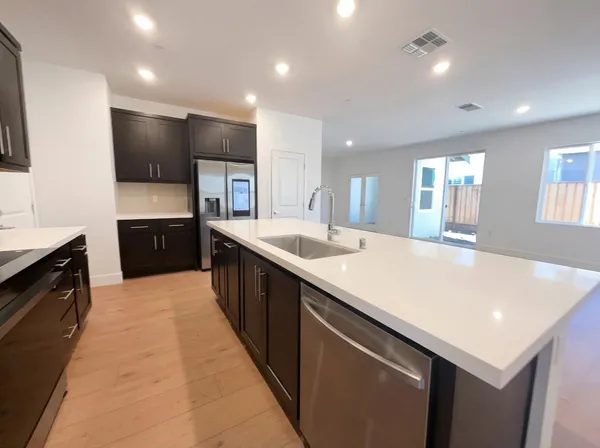 a large kitchen with stainless steel appliances a large counter top