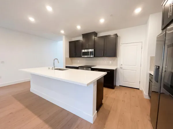 a kitchen with stainless steel appliances a refrigerator sink and stove