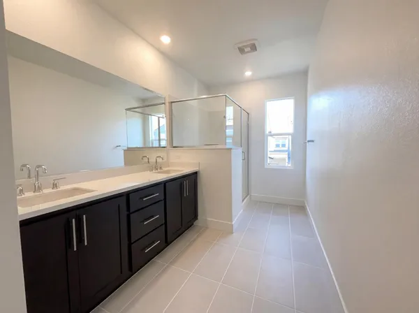 a spacious bathroom with a granite countertop sink a mirror and a vanity