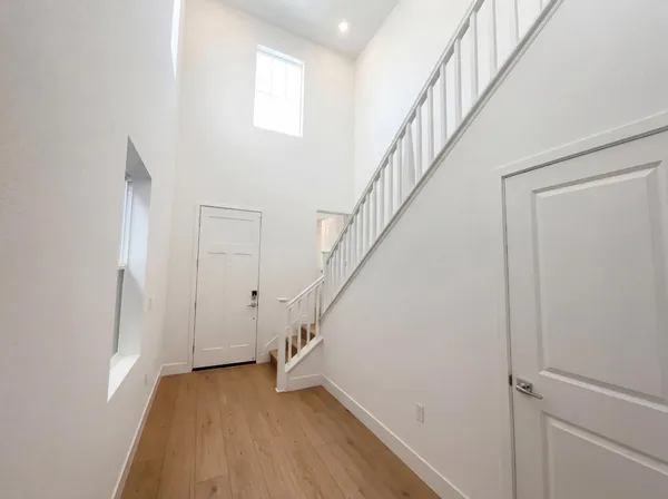 a view of staircase with wooden floor and white walls