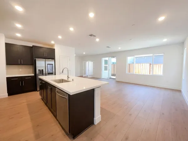 a kitchen with a stove and a wooden floor
