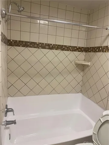 a bathroom with a bathtub and next to a white wall