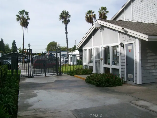 a view of a house with floor to ceiling window and potted plants