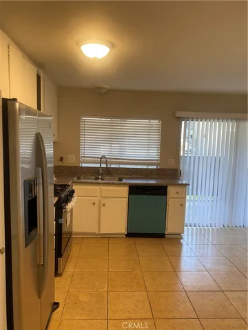 a kitchen with a sink a counter top space cabinets and stainless steel appliances