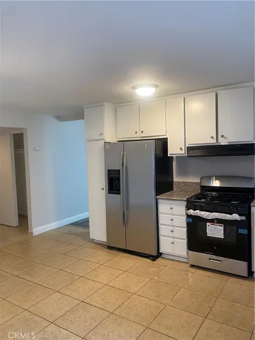 a kitchen with stainless steel appliances granite countertop a stove a refrigerator and a cabinets