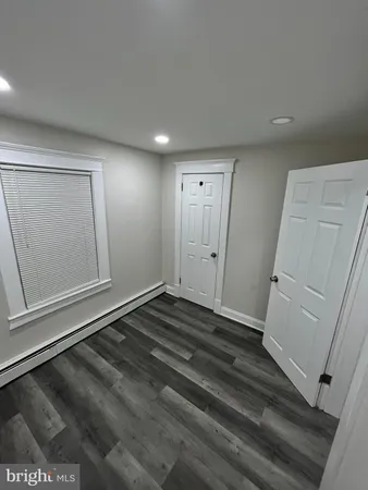 a view of a room with wooden floor and white walls