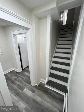 a view of a livingroom with wooden floor and stairs