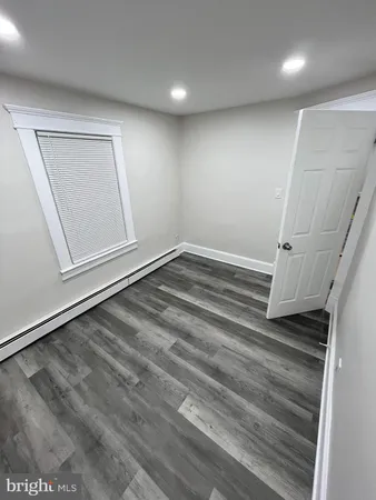 an empty room with wooden floor and window