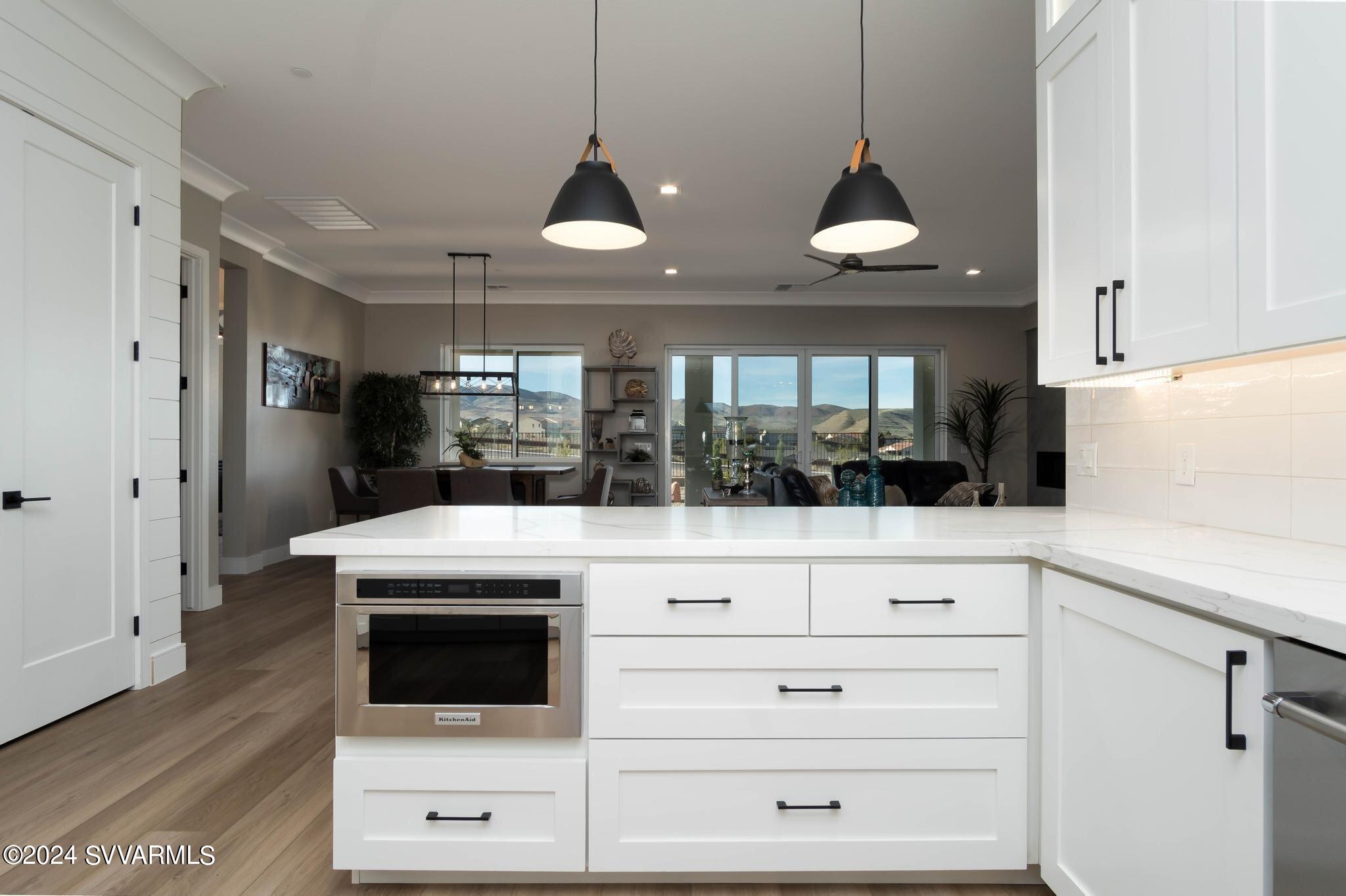 699 Moore Gulch Road, Unit LOT 117 Clarkdale, AZ 86324 - Photo 25 of 81 a kitchen with stainless steel appliances kitchen island white cabinets and wooden floor