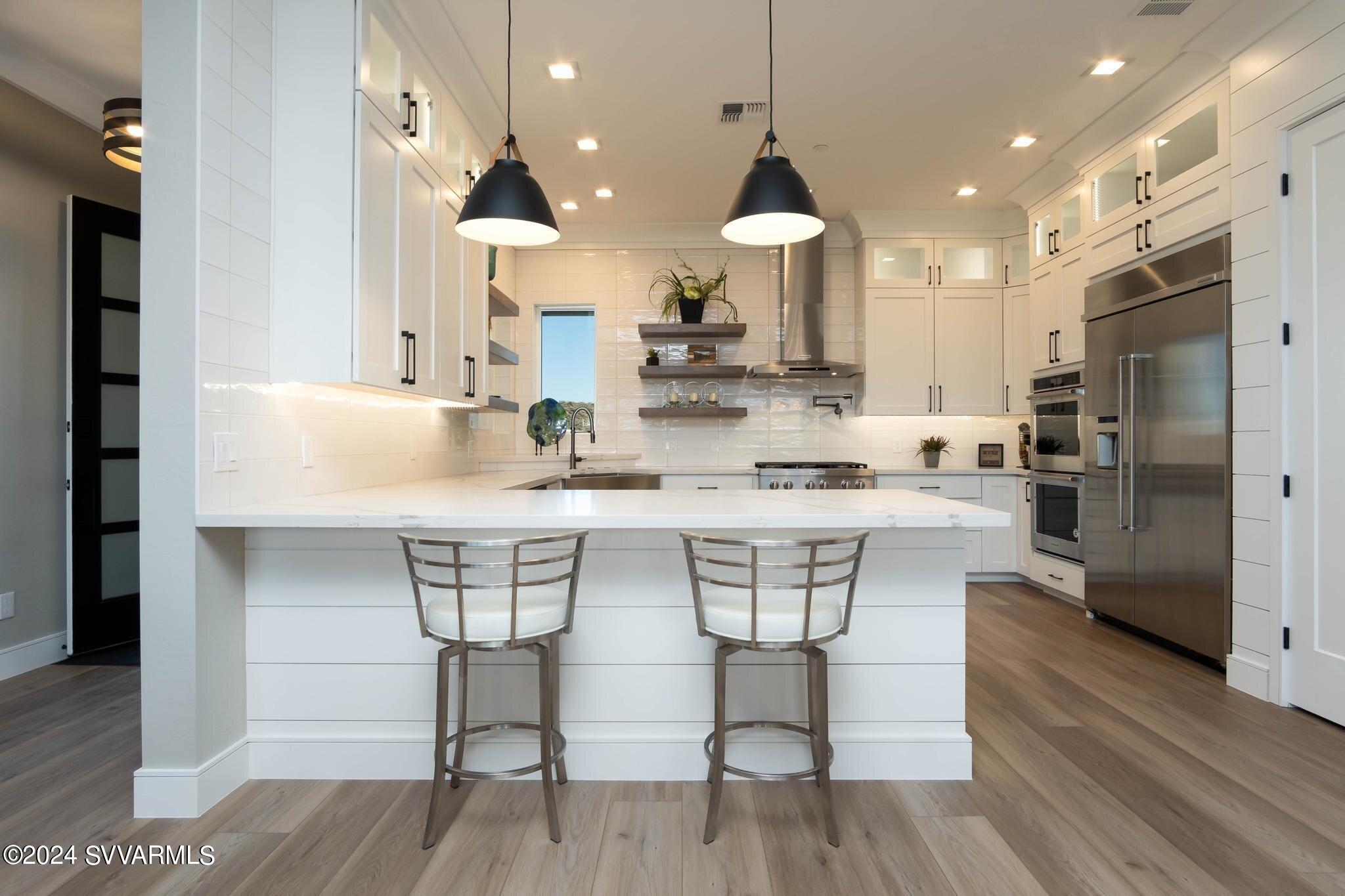 699 Moore Gulch Road, Unit LOT 117 Clarkdale, AZ 86324 - Photo 27 of 81 a kitchen with stainless steel appliances kitchen island granite countertop a dining table chairs sink and cabinets