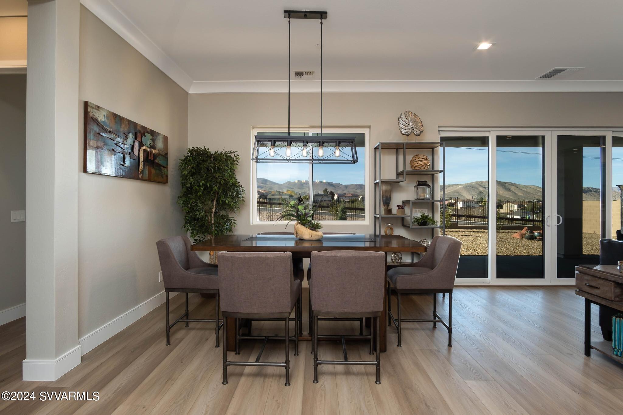 699 Moore Gulch Road, Unit LOT 117 Clarkdale, AZ 86324 - Photo 29 of 81 a dining room with furniture a chandelier and wooden floor