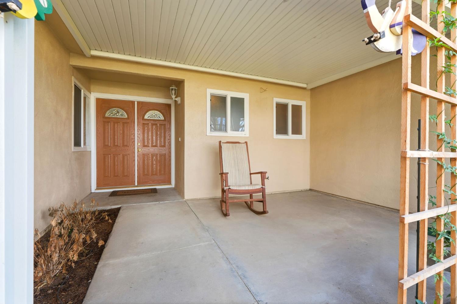 905 Redwood Lane Lemoore, CA 93245 - Photo 13 of 56 a view of a house with a bench and floor to ceiling window
