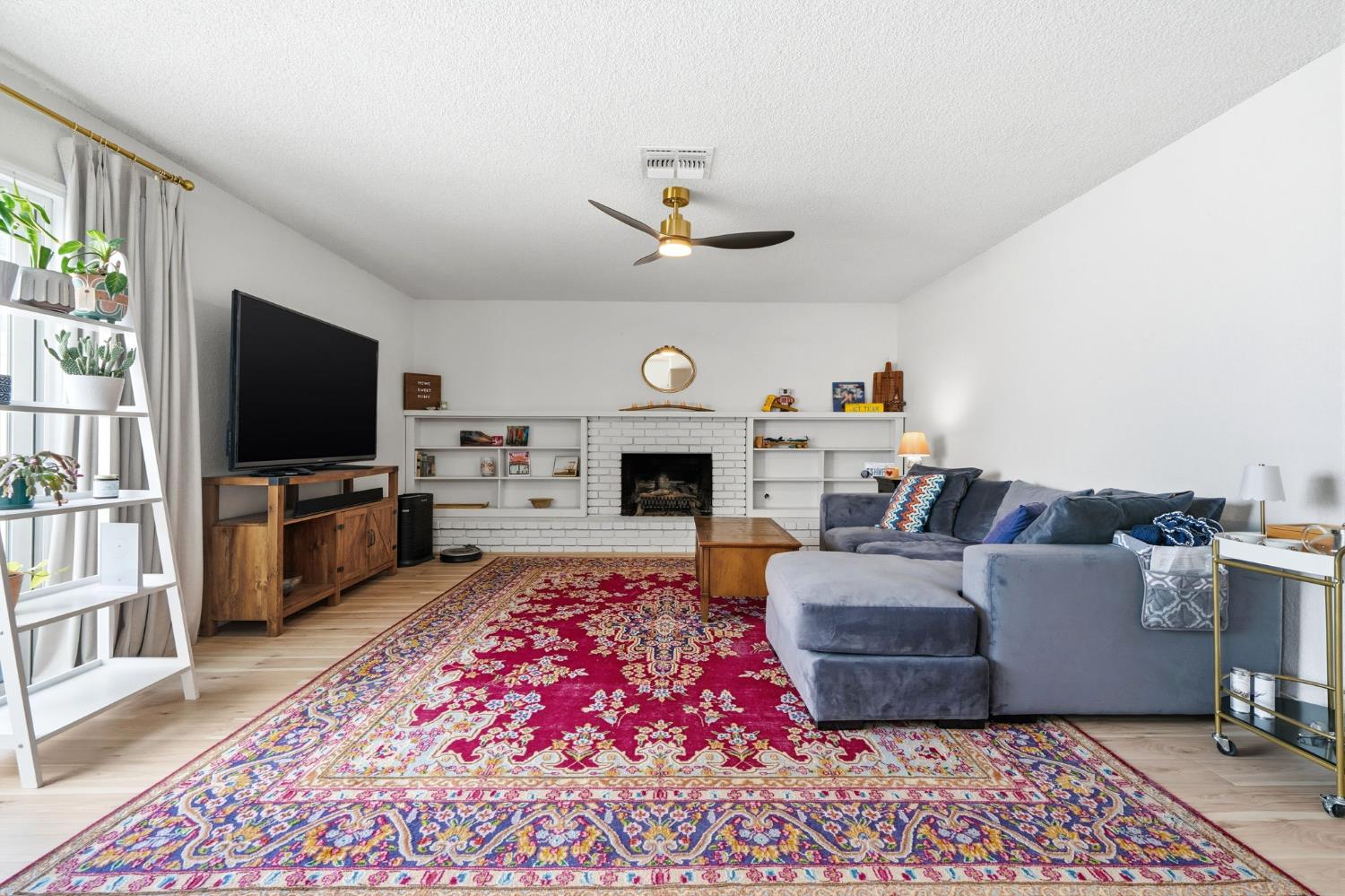 905 Redwood Lane Lemoore, CA 93245 - Photo 20 of 56 a living room with furniture a flat screen tv and a fireplace