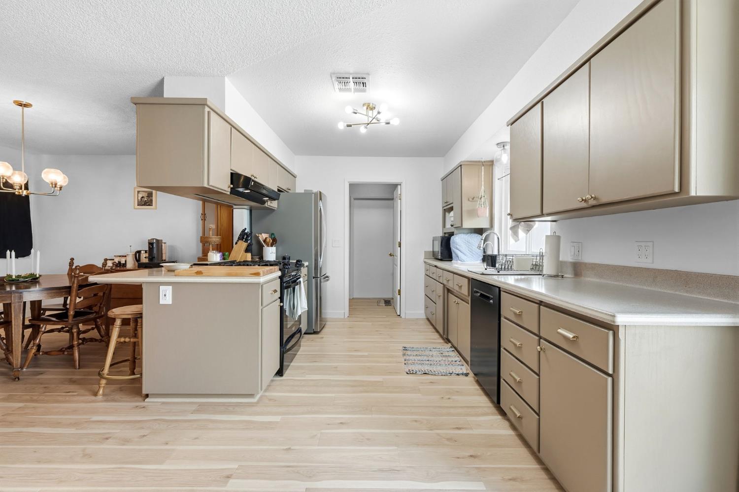 905 Redwood Lane Lemoore, CA 93245 - Photo 24 of 56 a large kitchen with stainless steel appliances kitchen island granite countertop a large counter top and cabinets