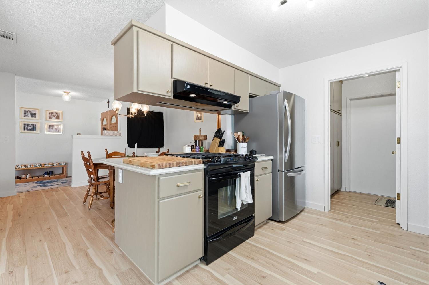 905 Redwood Lane Lemoore, CA 93245 - Photo 26 of 56 a kitchen with stainless steel appliances a stove top oven a refrigerator and chairs