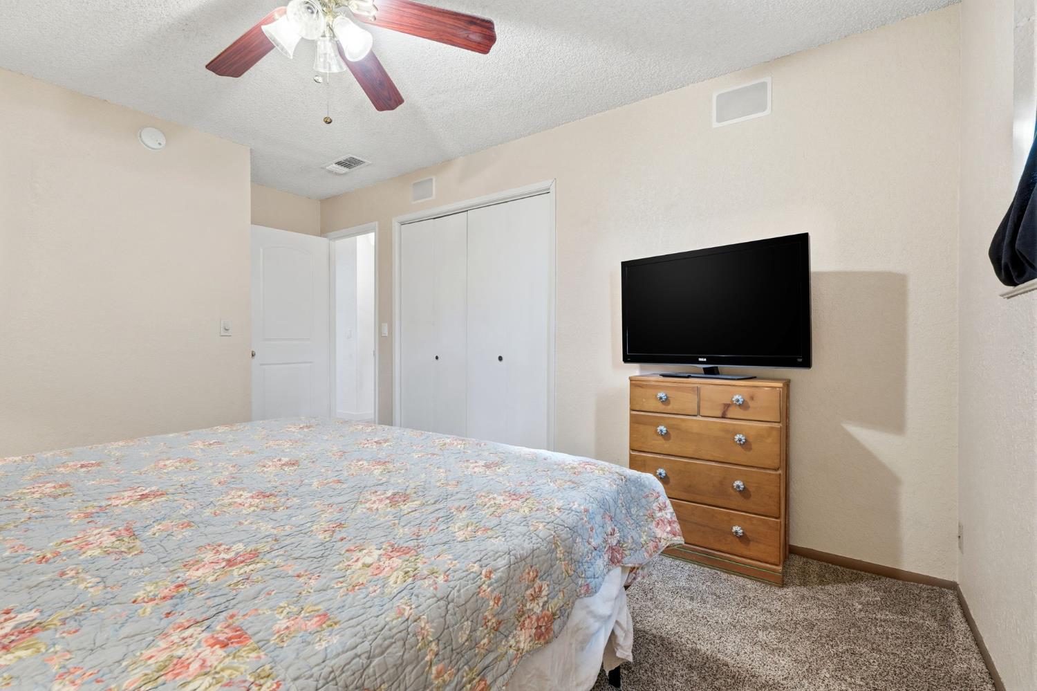 905 Redwood Lane Lemoore, CA 93245 - Photo 37 of 56 a bedroom with a bed and a flat screen tv