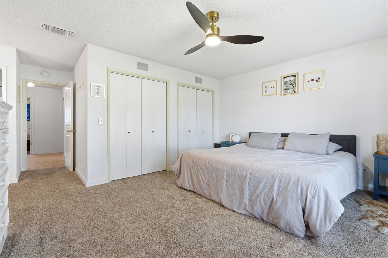 905 Redwood Lane Lemoore, CA 93245 - Photo 42 of 56 a spacious bedroom with a bed and a ceiling fan