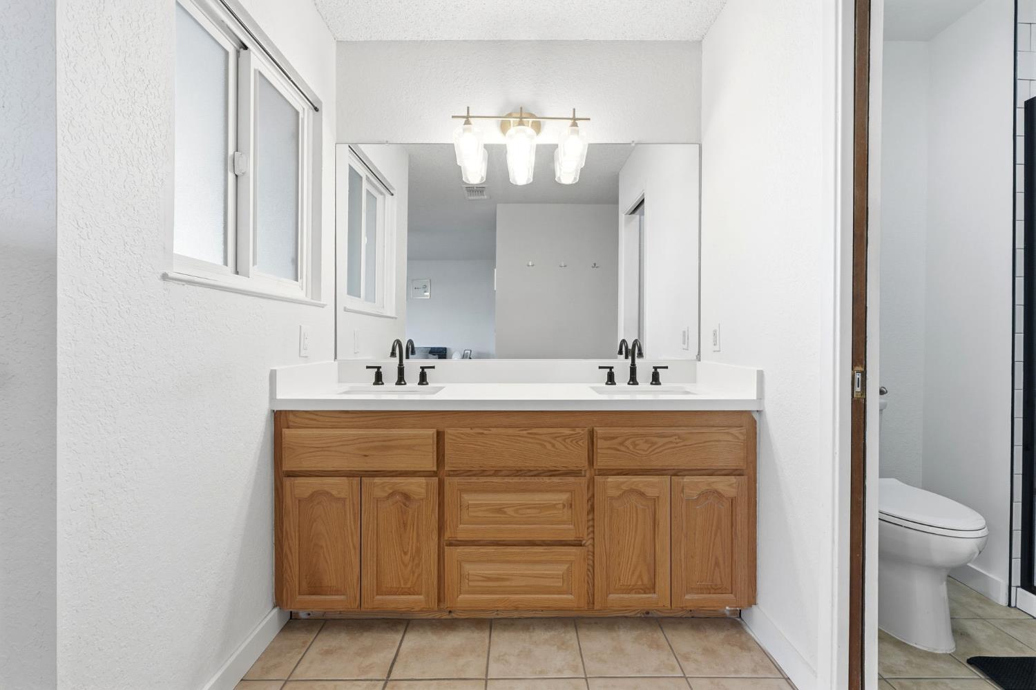 905 Redwood Lane Lemoore, CA 93245 - Photo 44 of 56 a bathroom with a sink vanity and a mirror