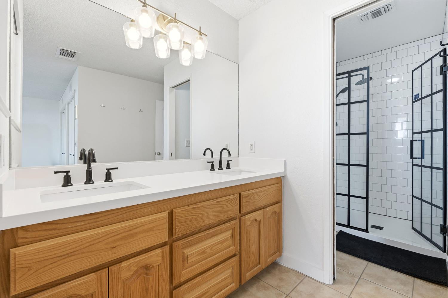 905 Redwood Lane Lemoore, CA 93245 - Photo 45 of 56 a bathroom with a double vanity sink and a mirror