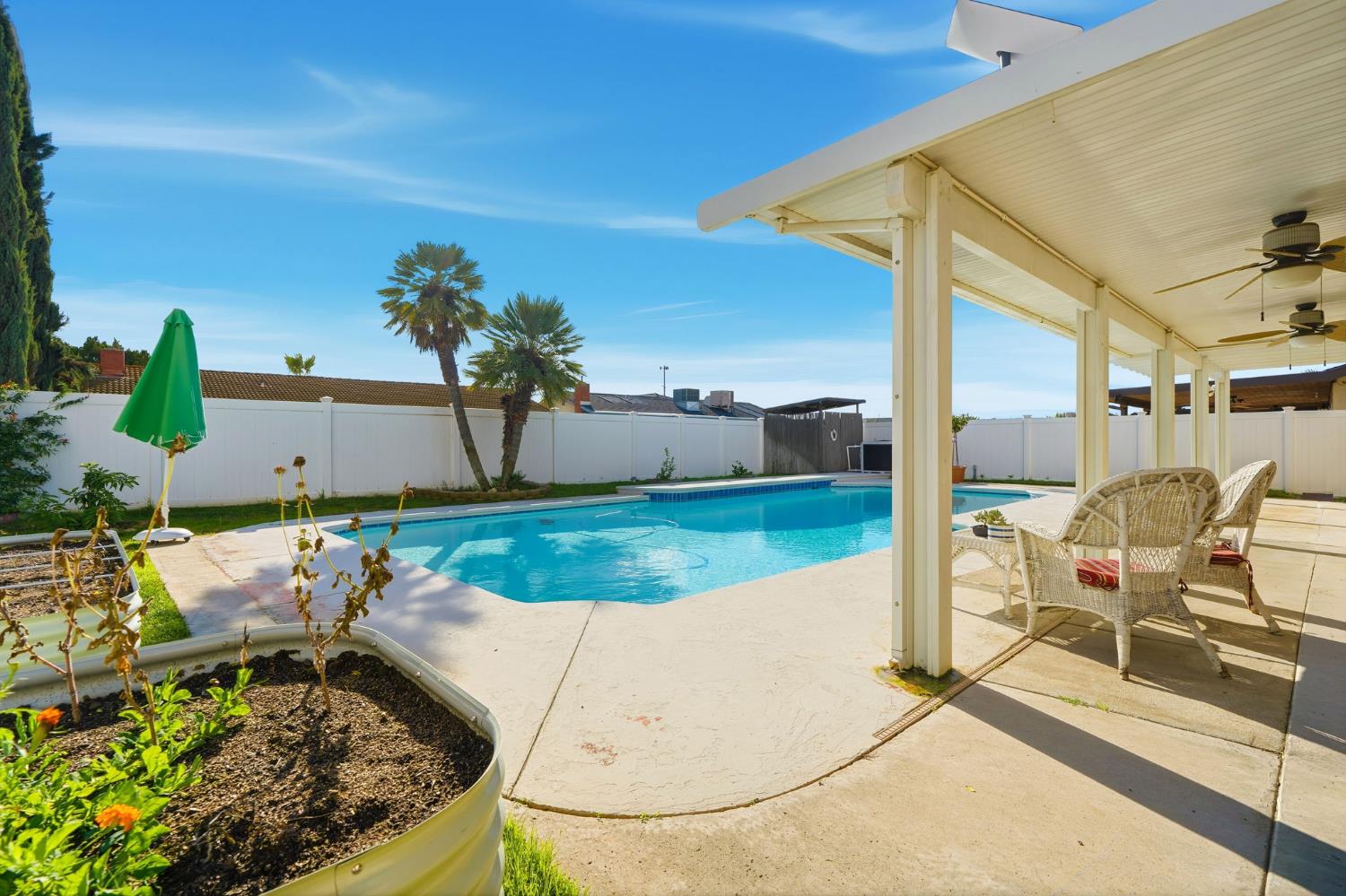 905 Redwood Lane Lemoore, CA 93245 - Photo 49 of 56 a view of a swimming pool with a lounge chairs