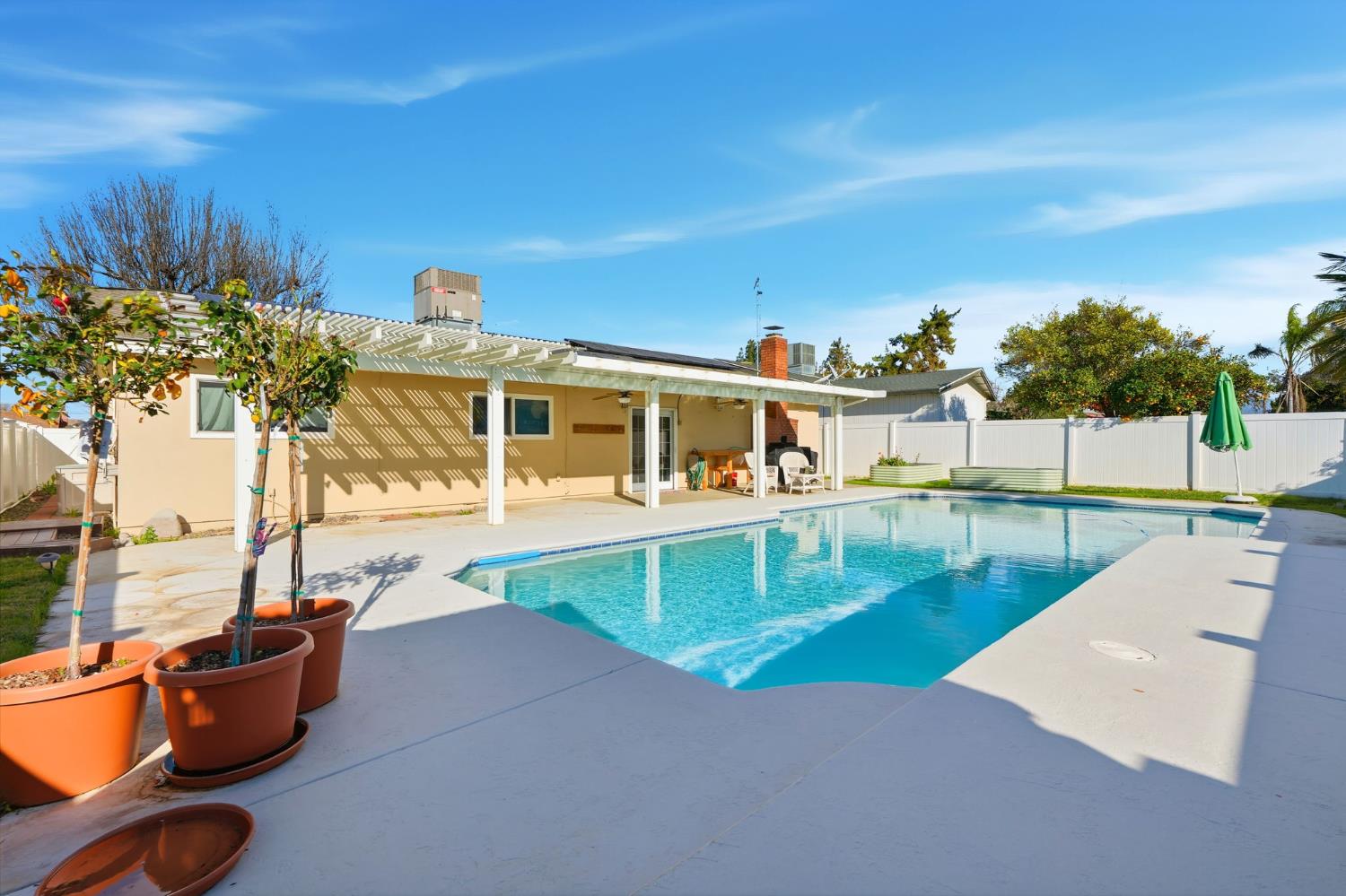 905 Redwood Lane Lemoore, CA 93245 - Photo 51 of 56 a view of a swimming pool with a lounge chairs