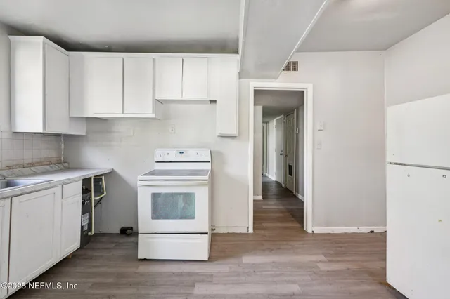 a kitchen with a stove and white cabinets