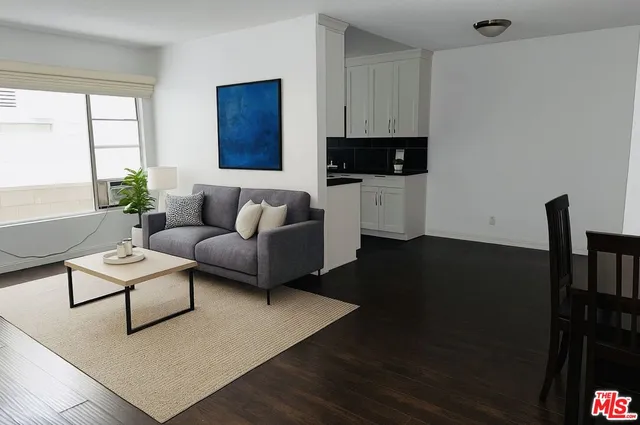 a living room with furniture a flat screen tv and a window