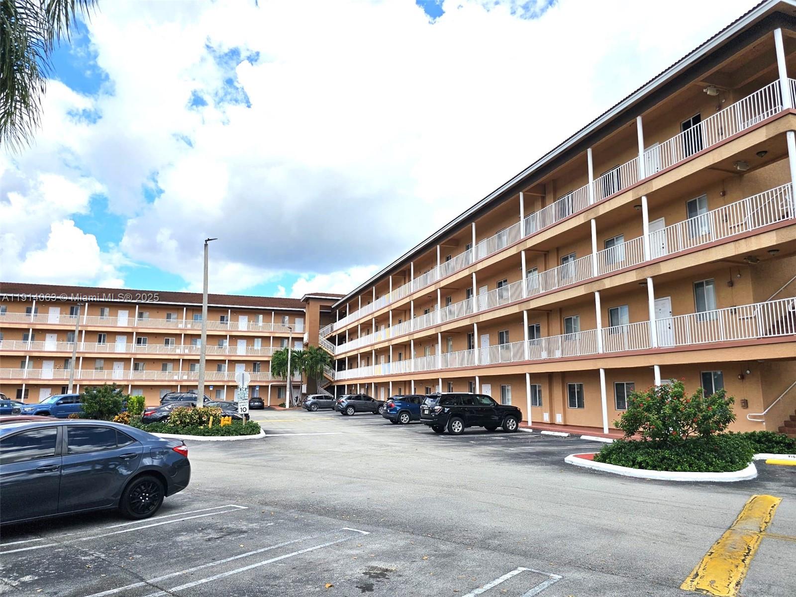 17350 Northwest 67th Avenue, Unit 303 Hialeah, FL 33015 - Photo 3 of 10 a front view of a building with lot of cars parked