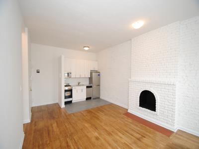 a view of kitchen and empty room with fireplace
