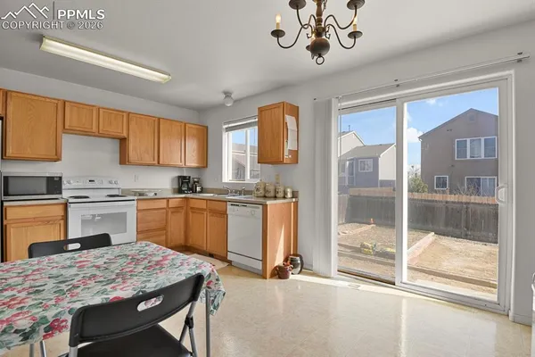 a kitchen with a refrigerator a stove a sink dishwasher with a dining table and chairs