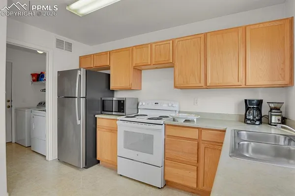 a kitchen with a refrigerator sink and cabinets