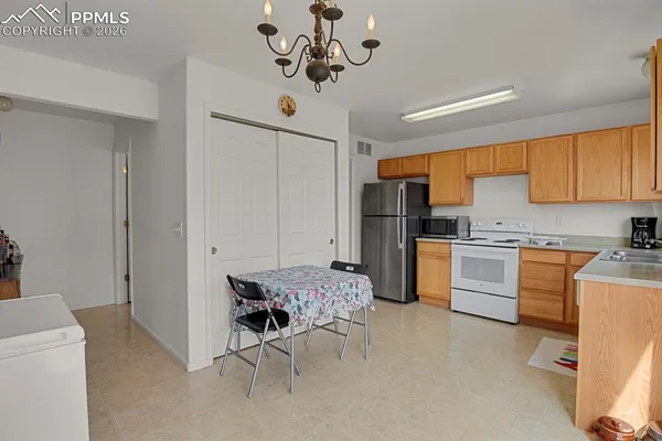 a kitchen with a refrigerator a stove cabinets and living room view