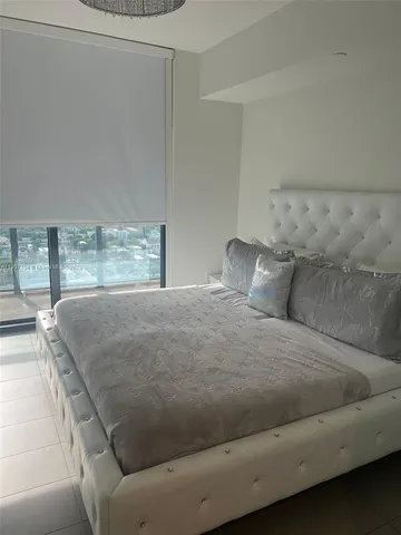 a bed sitting in a bedroom next to a window