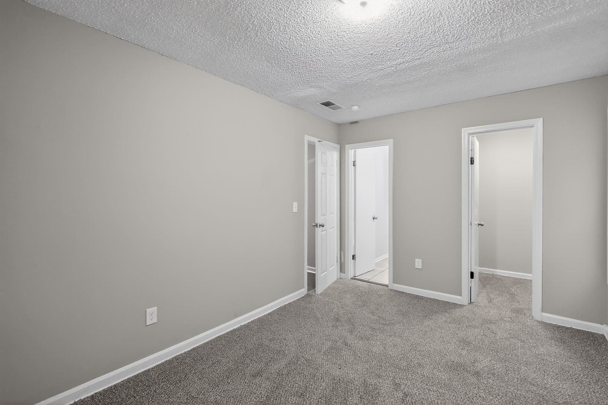 4725 Lofts Road Memphis, TN 38118 - Photo 18 of 32 Unfurnished bedroom featuring a walk in closet, a textured ceiling, and carpet floors
