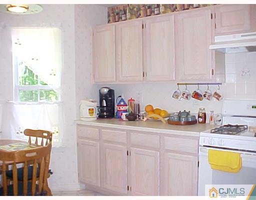 246 Hawthorne Road North Brunswick, NJ 08902 - Photo 2 of 4 a kitchen with stainless steel appliances a white cabinets a stove a sink and a window