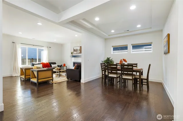 a living room with furniture a dining table and wooden floor
